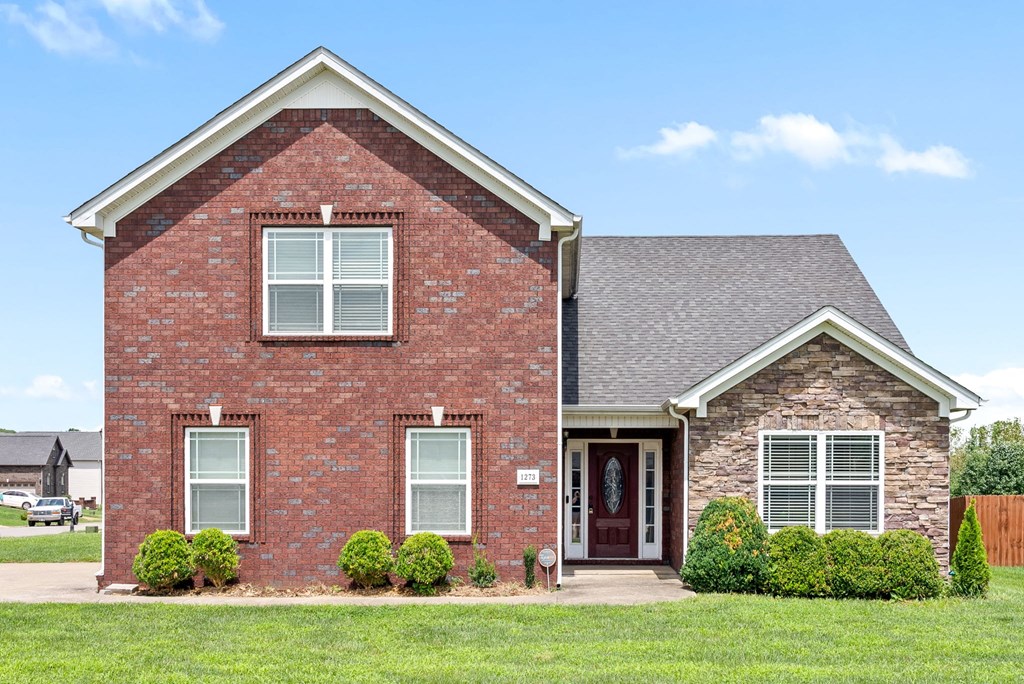a brick house with a lawn in front of it