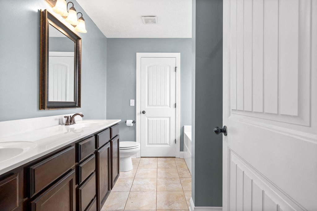 a bathroom with a white door and a sink and a toilet