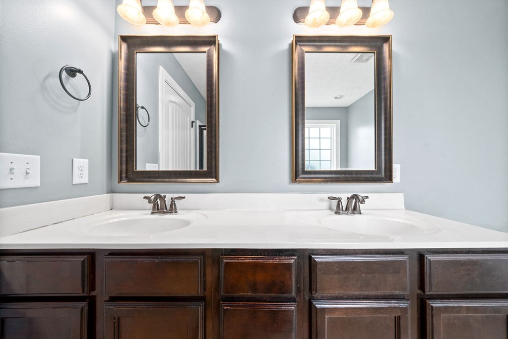 a bathroom with two sinks and two mirrors
