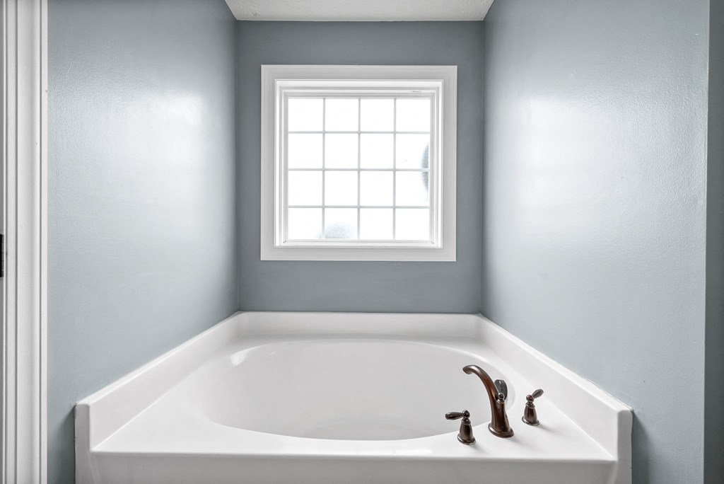 a bathroom with a bath tub and a window