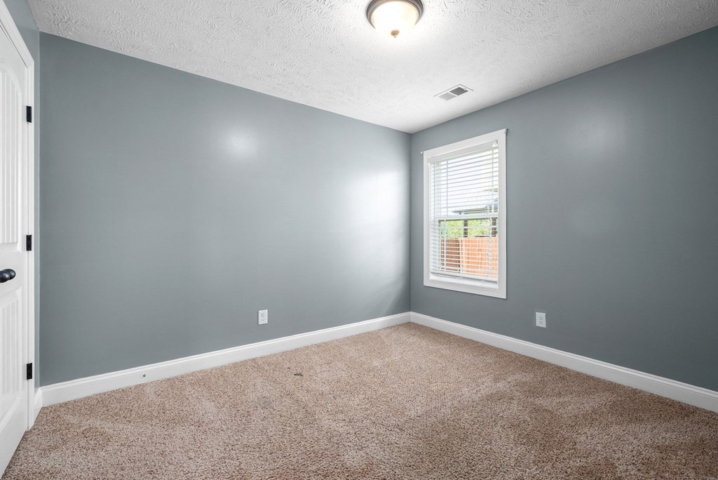 an empty room with carpet and a window
