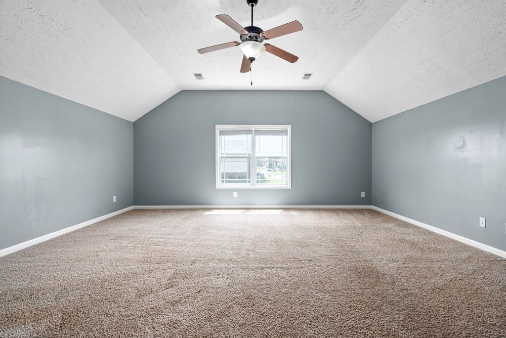an empty room with a ceiling fan and a window