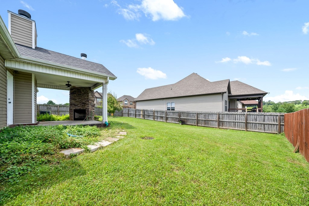 the back yard of a house with a fence and a patio