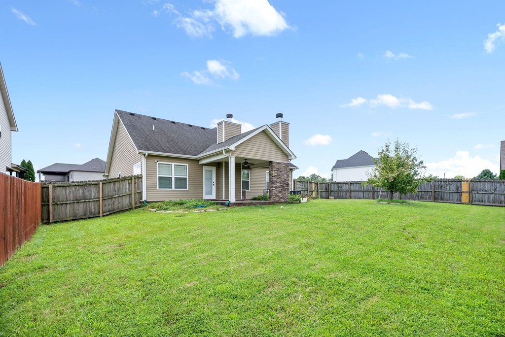 the backyard of a house with a yard and a fence