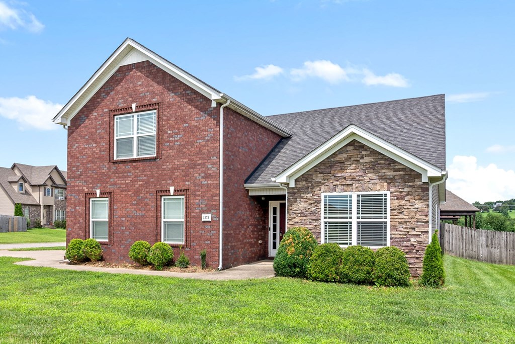 a brick house with a lawn in front of it
