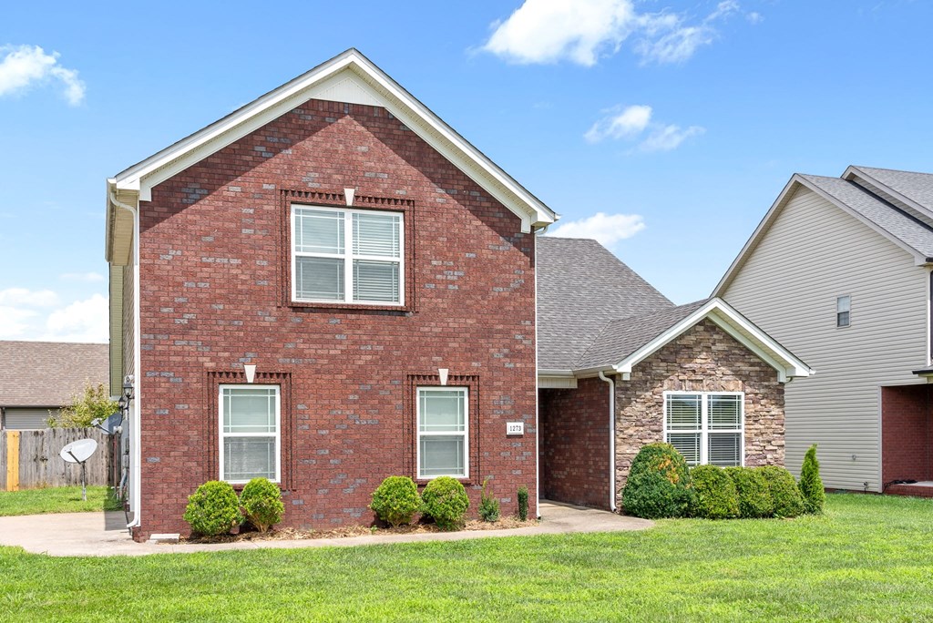 a brick house with a yard in front of it