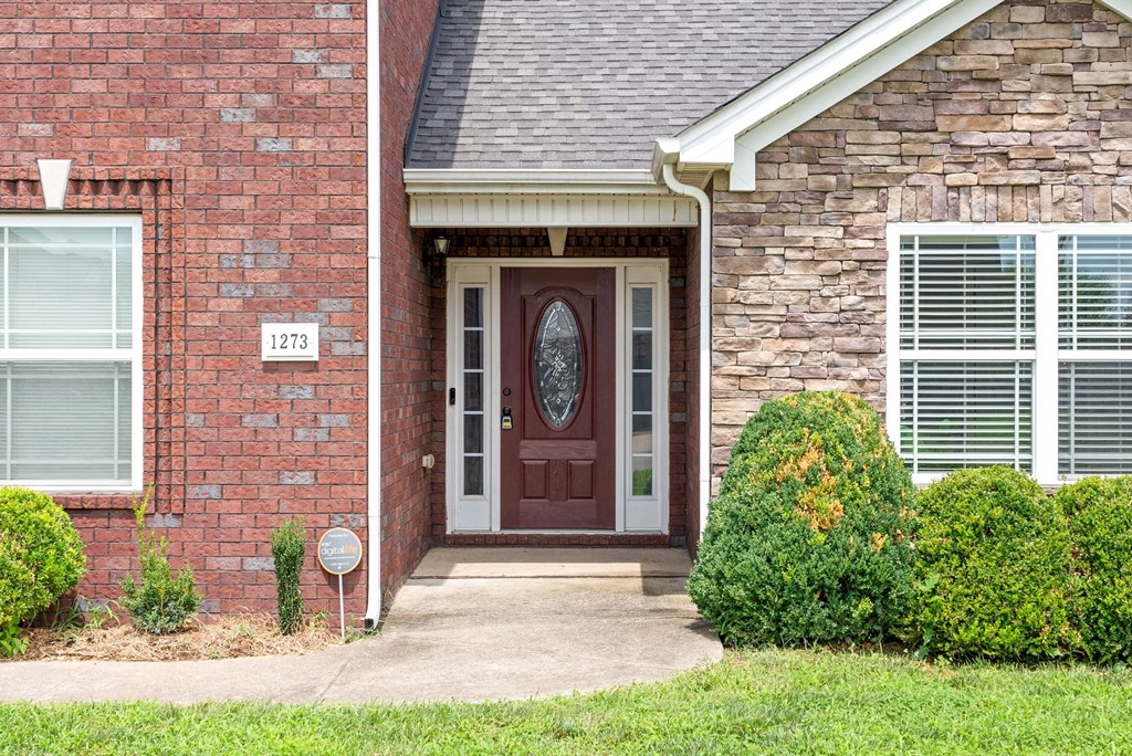 the front door of a brick house with a porch