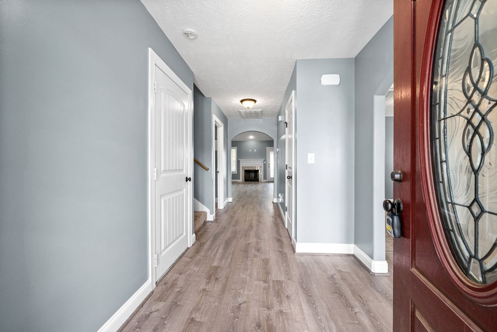the hallway of a house with blue walls and wood floors