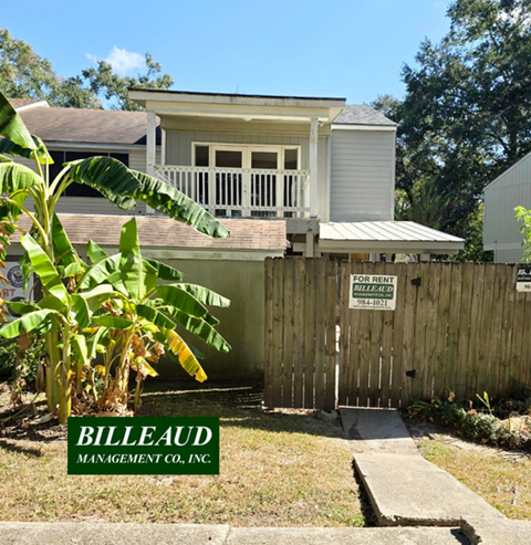 A house with a "For Rent" sign in front of it.