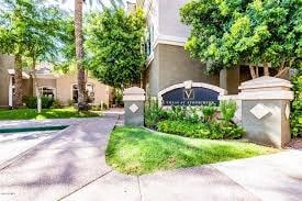 an apartment building with a driveway and a sign in front of it