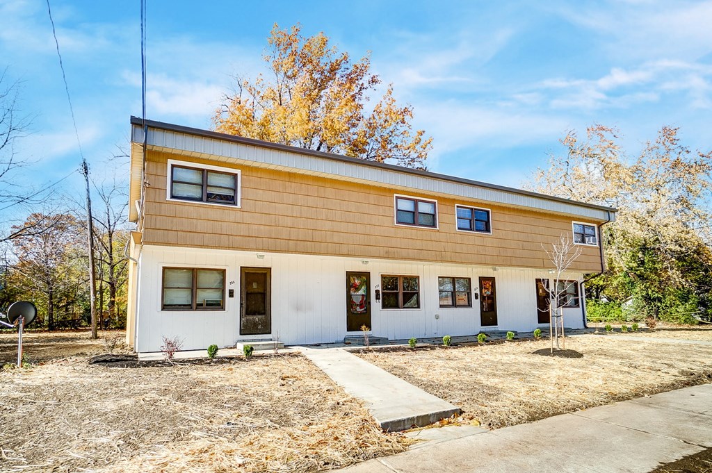 the front of a house with a yard and a sidewalk