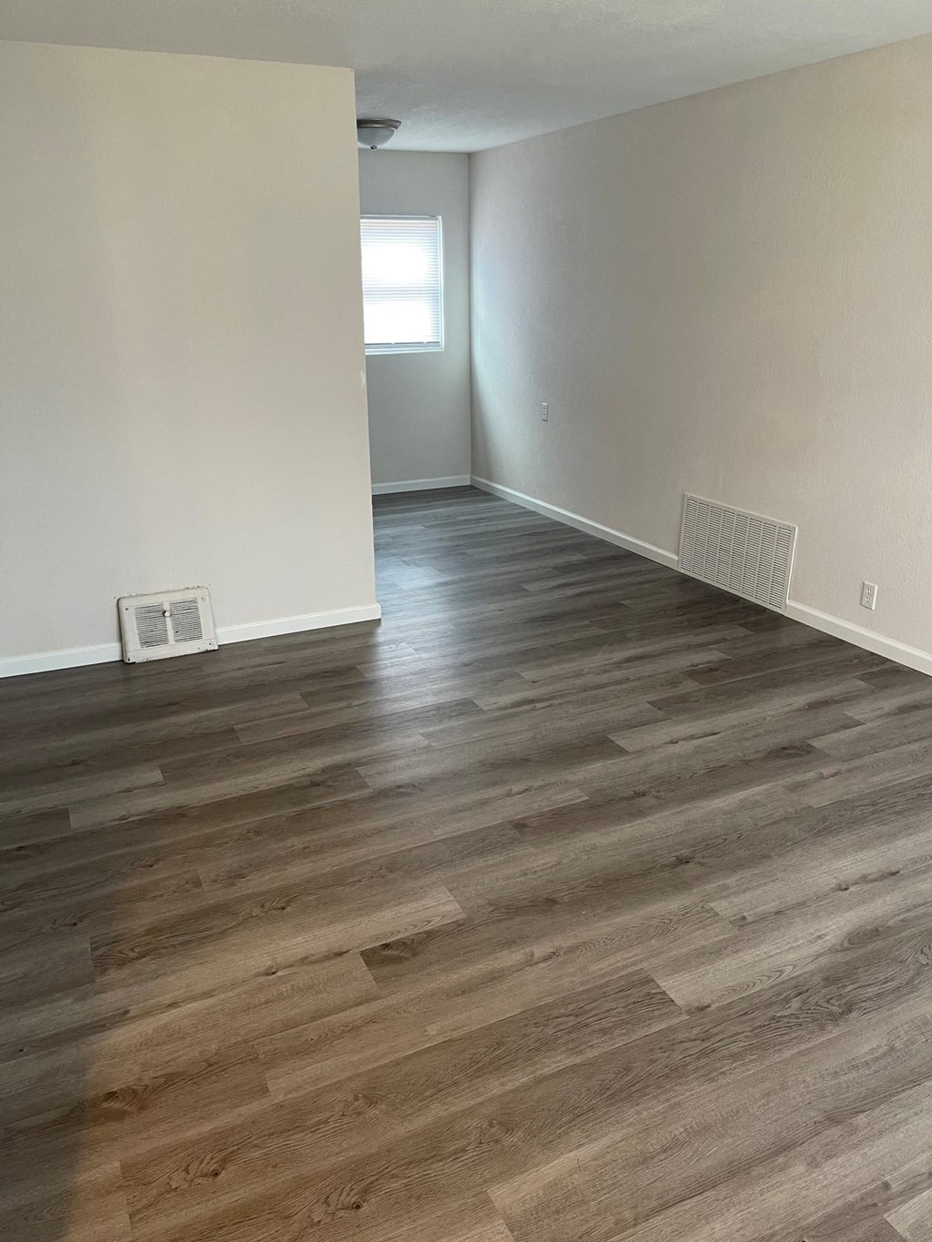 the living room of an empty house with wood flooring