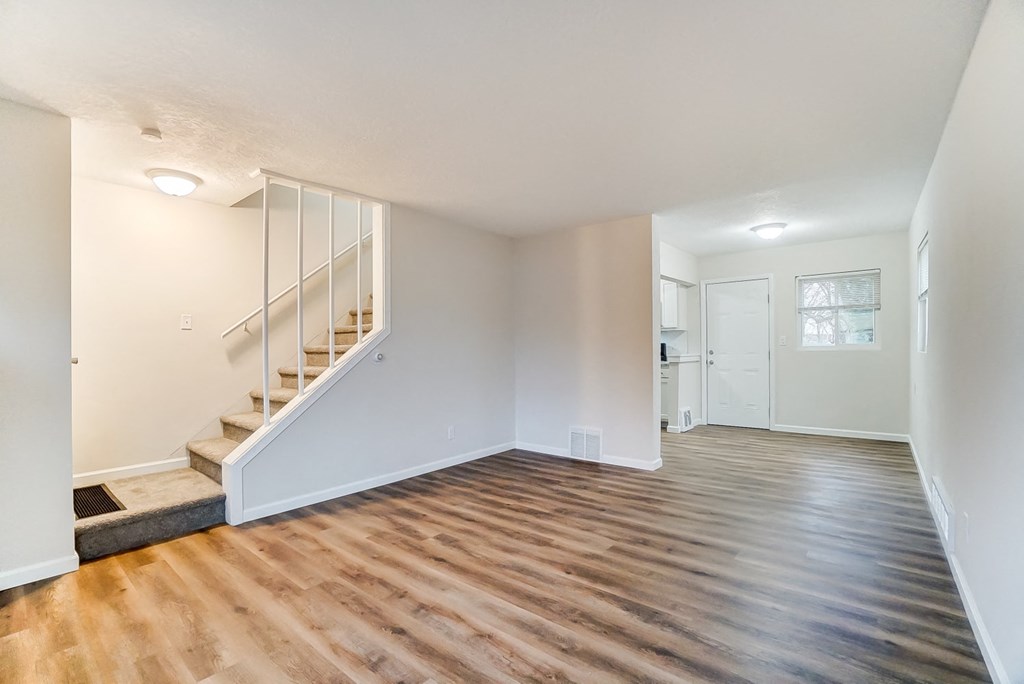 a living room with a hard wood floor and a staircase