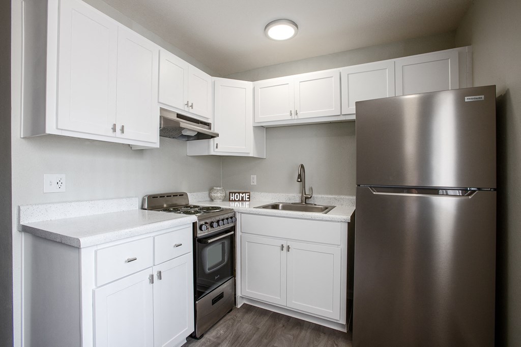 a kitchen with white cabinets and a stainless steel refrigerator