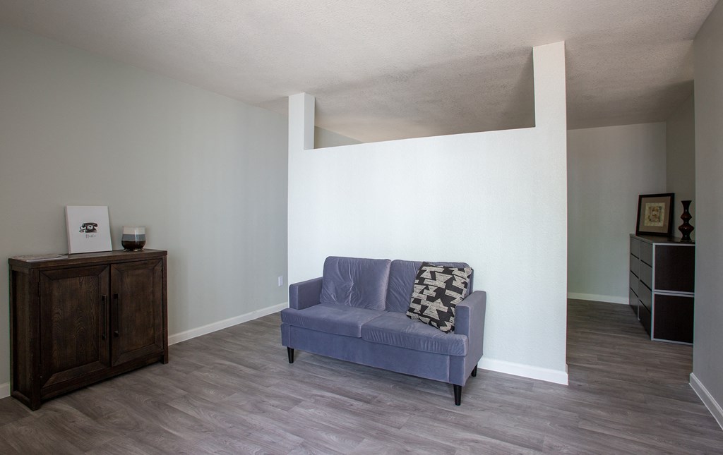 a living room with a blue couch and a white wall