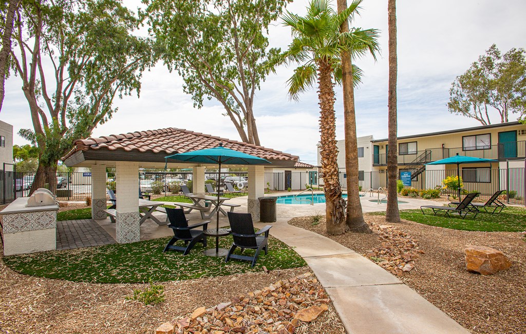 our apartments have a pool and a patio with chairs and umbrellas