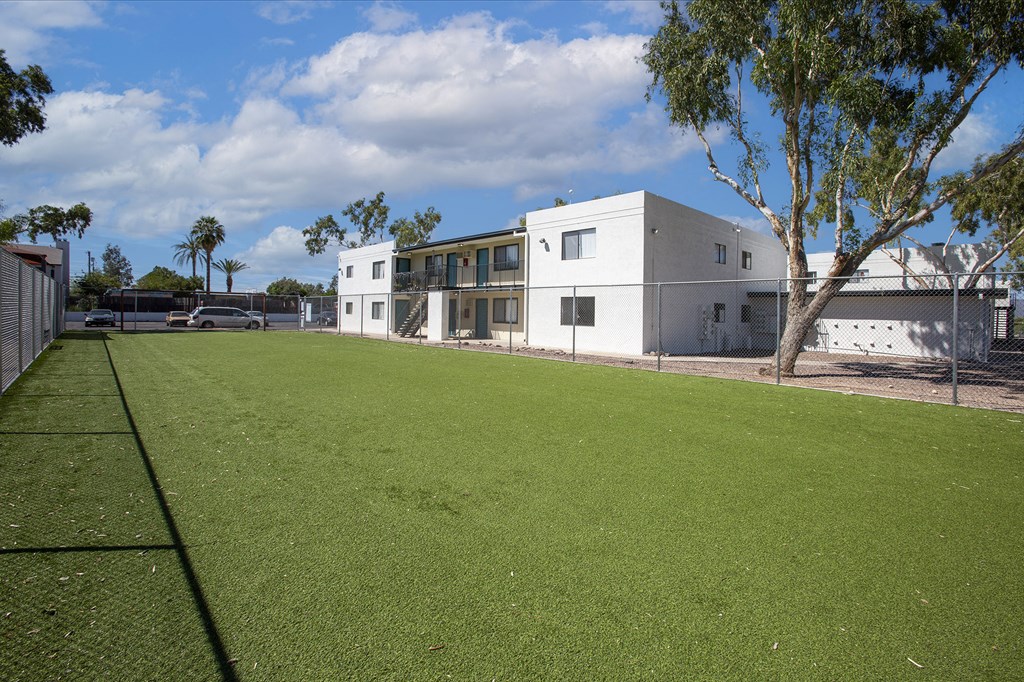 a yard in front of a white house with a green lawn
