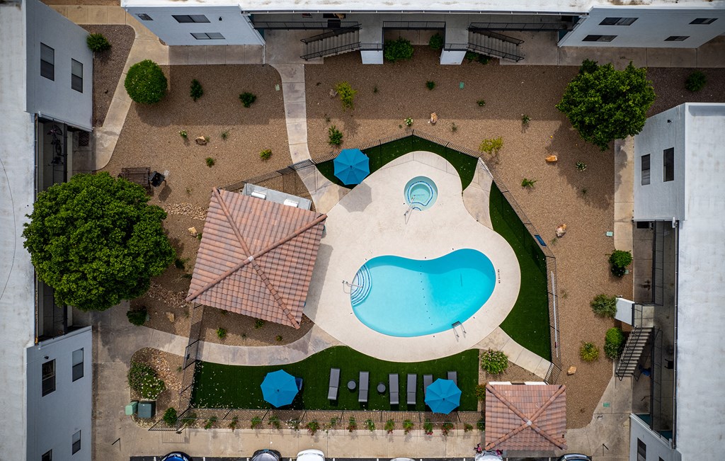 a birds eye view of a swimming pool in the middle of a hotel yard