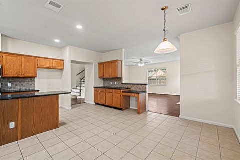 A kitchen with wooden cabinets and a black countertop.