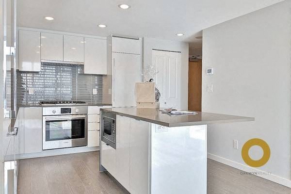 a white kitchen with a counter top and a stove