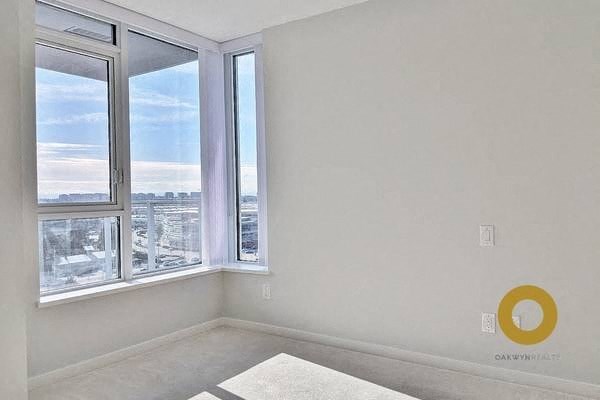 an empty room with a large window and a rug
