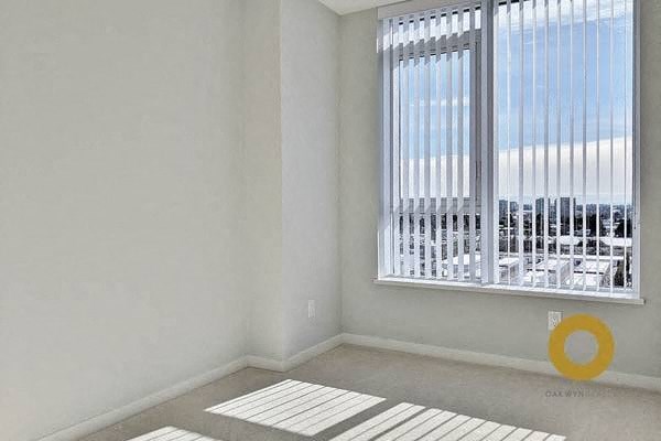 an empty room with a large window and a rug