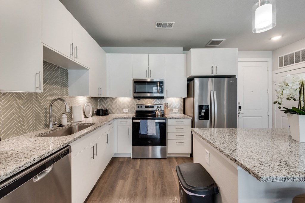 an open kitchen with granite counter tops and stainless steel appliances