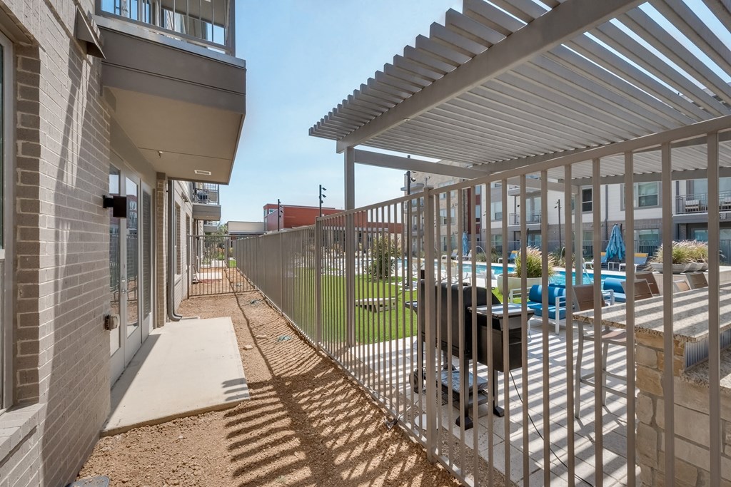 the courtyard of a building with a fence and tables and chairs