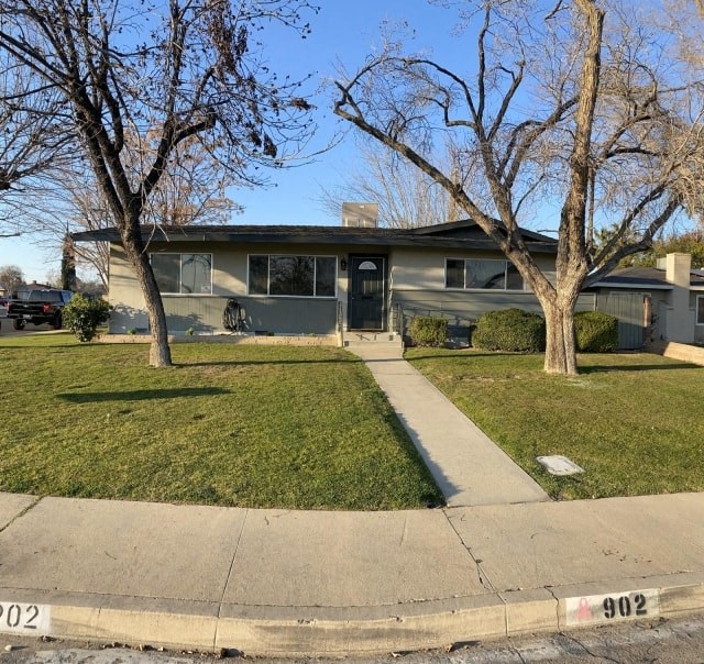 the front of a house with two trees and a sidewalk