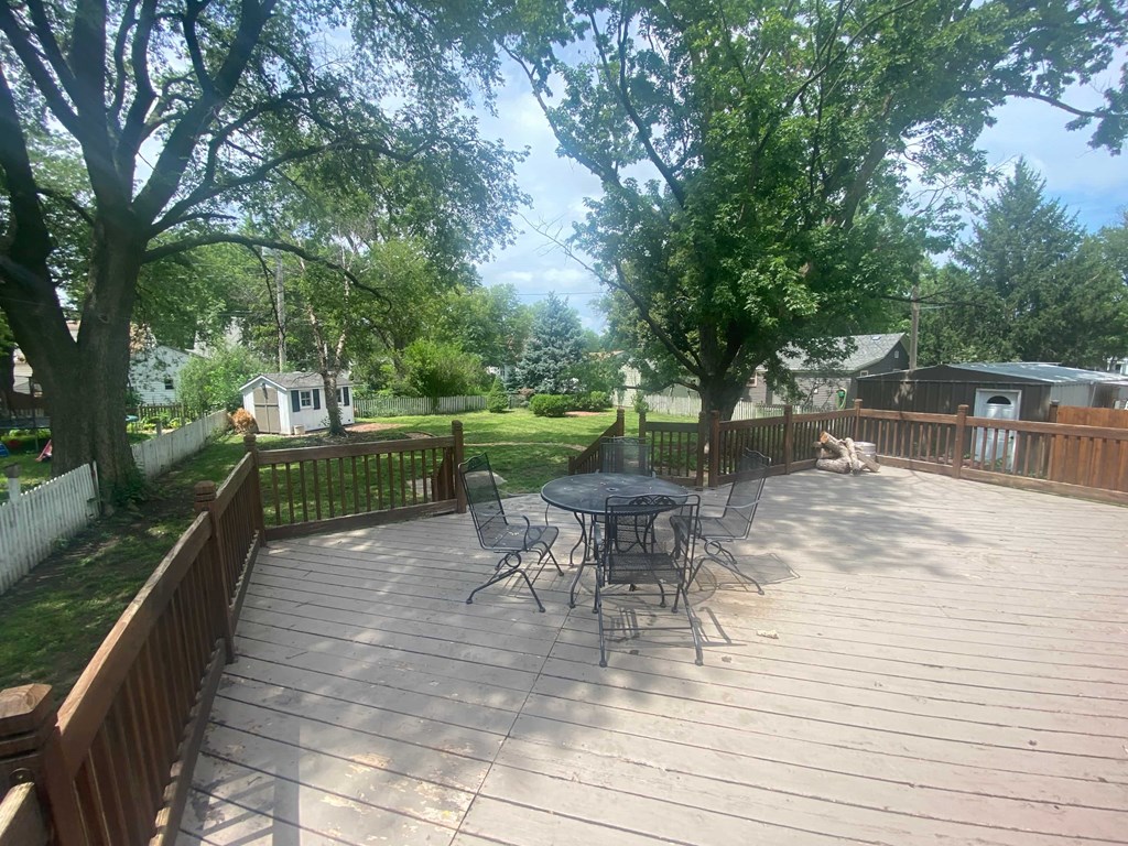 a patio with a table and chairs on a wooden deck