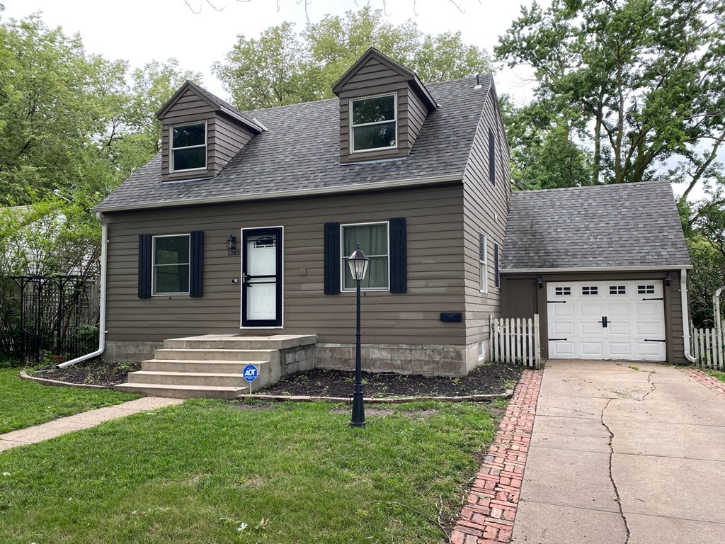 a brown house with a white garage and a street light