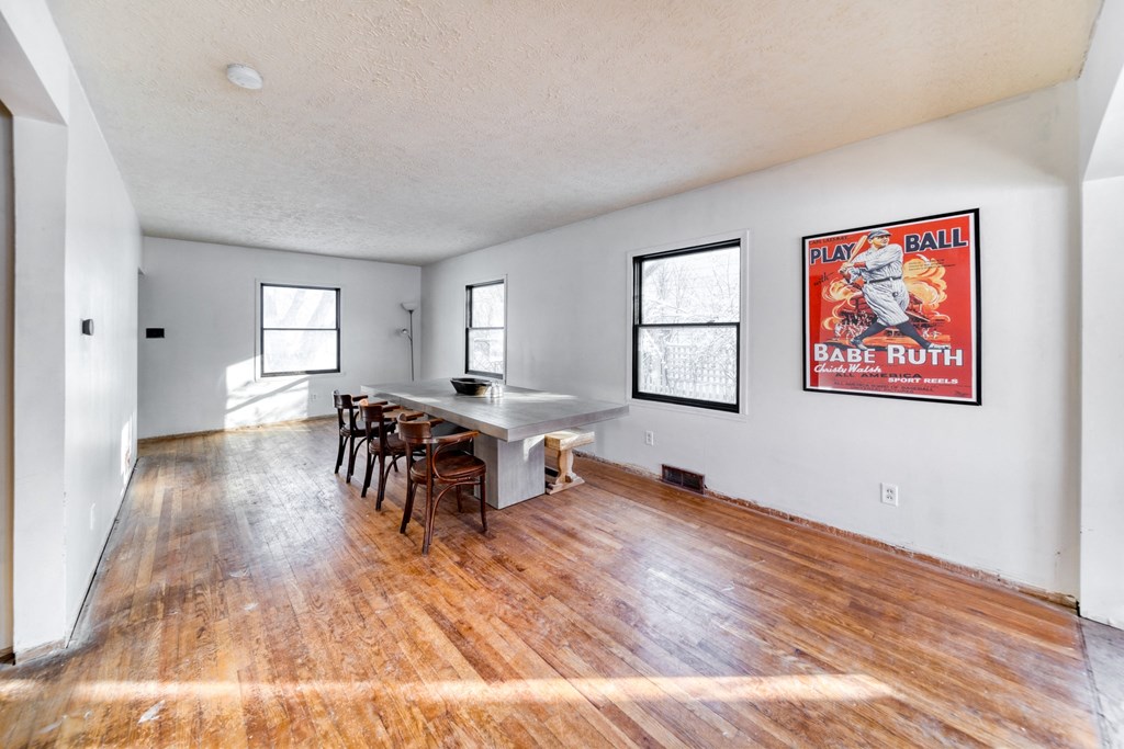 the living room and dining room of a house with hardwood floors and a table