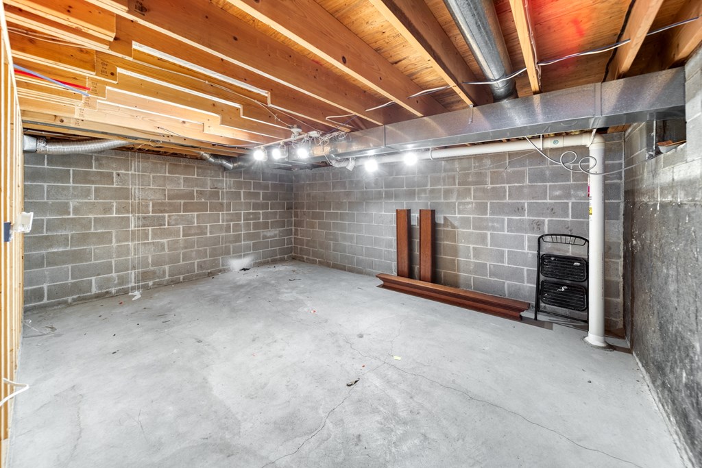 the basement of a home with a brick wall and wood beams