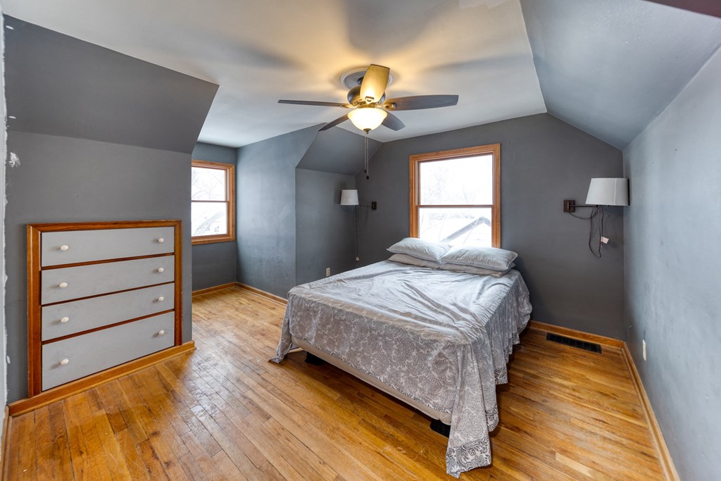 a bedroom with a bed and a ceiling fan