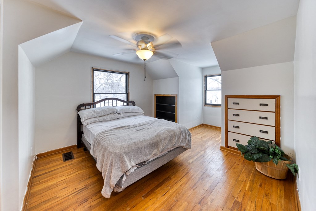 an attic bedroom with a bed and a ceiling fan