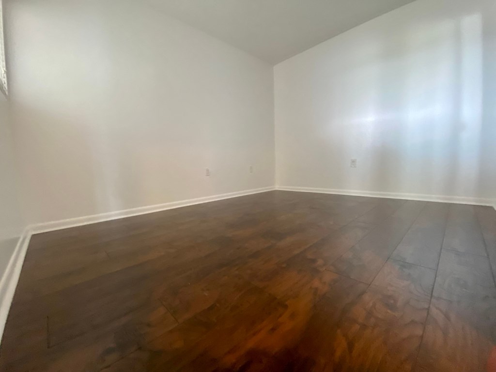 an empty room with wooden floors and white walls