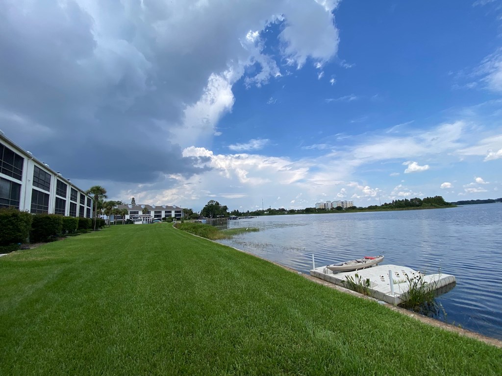 a large body of water next to a building with a boat on it