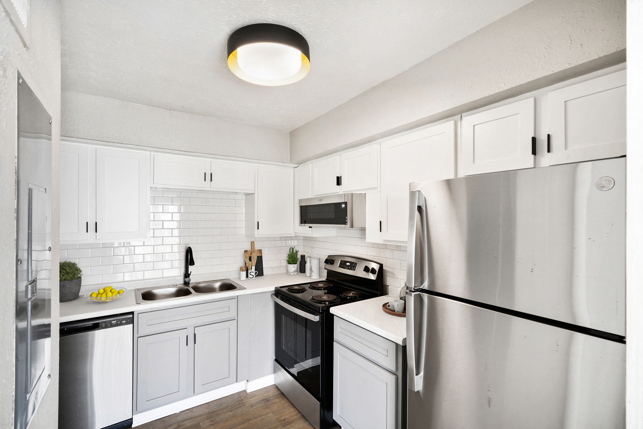 A white kitchen with a black stove top oven.