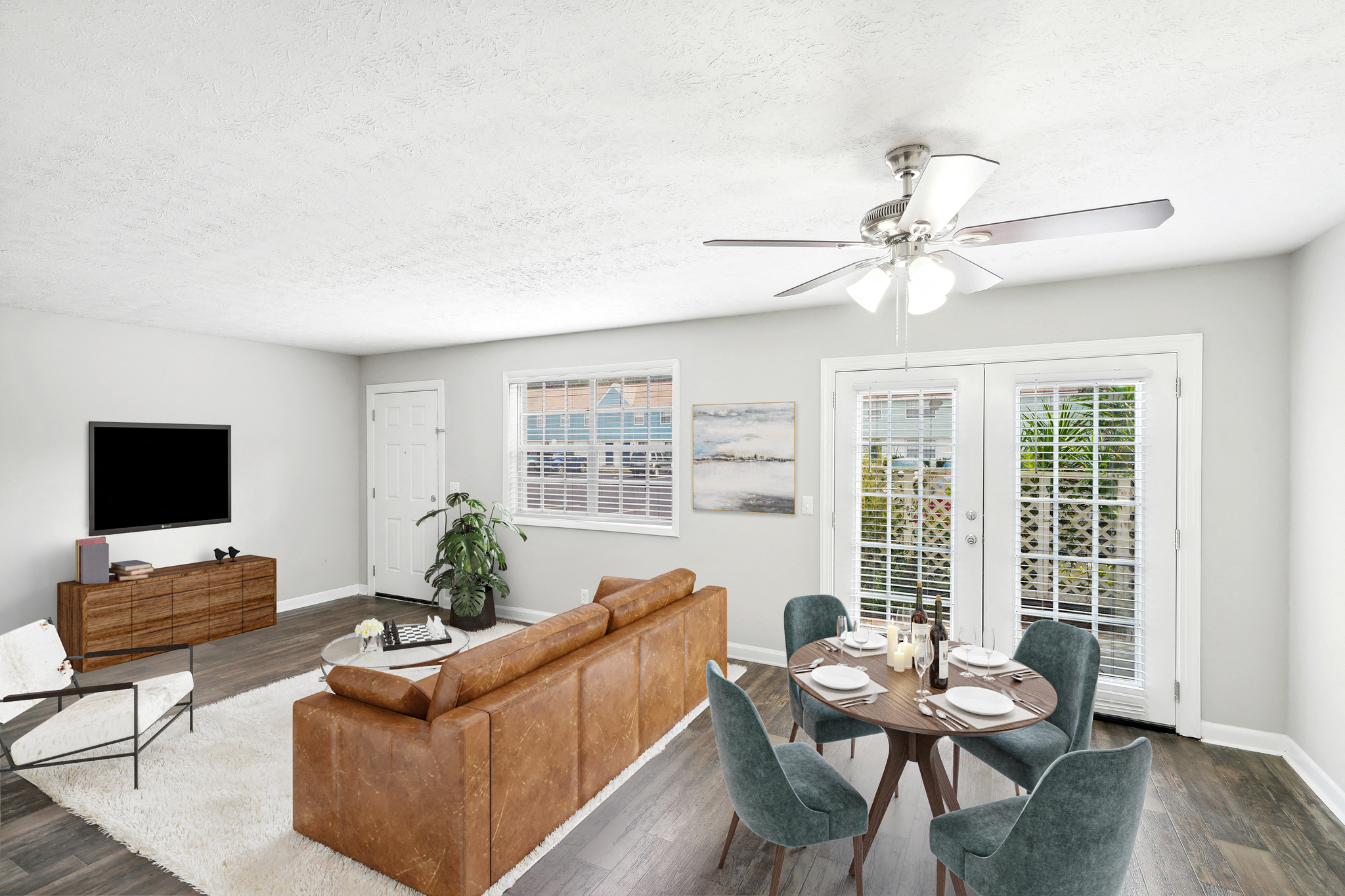 A living room with a brown couch, a television, and a dining table with chairs.