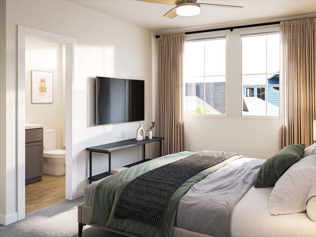 a bedroom with a bed and a bathroom with a tv