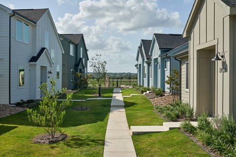 A row of houses with a sidewalk in between.