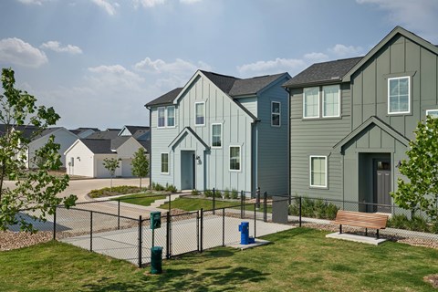 A row of houses with a fence in front.