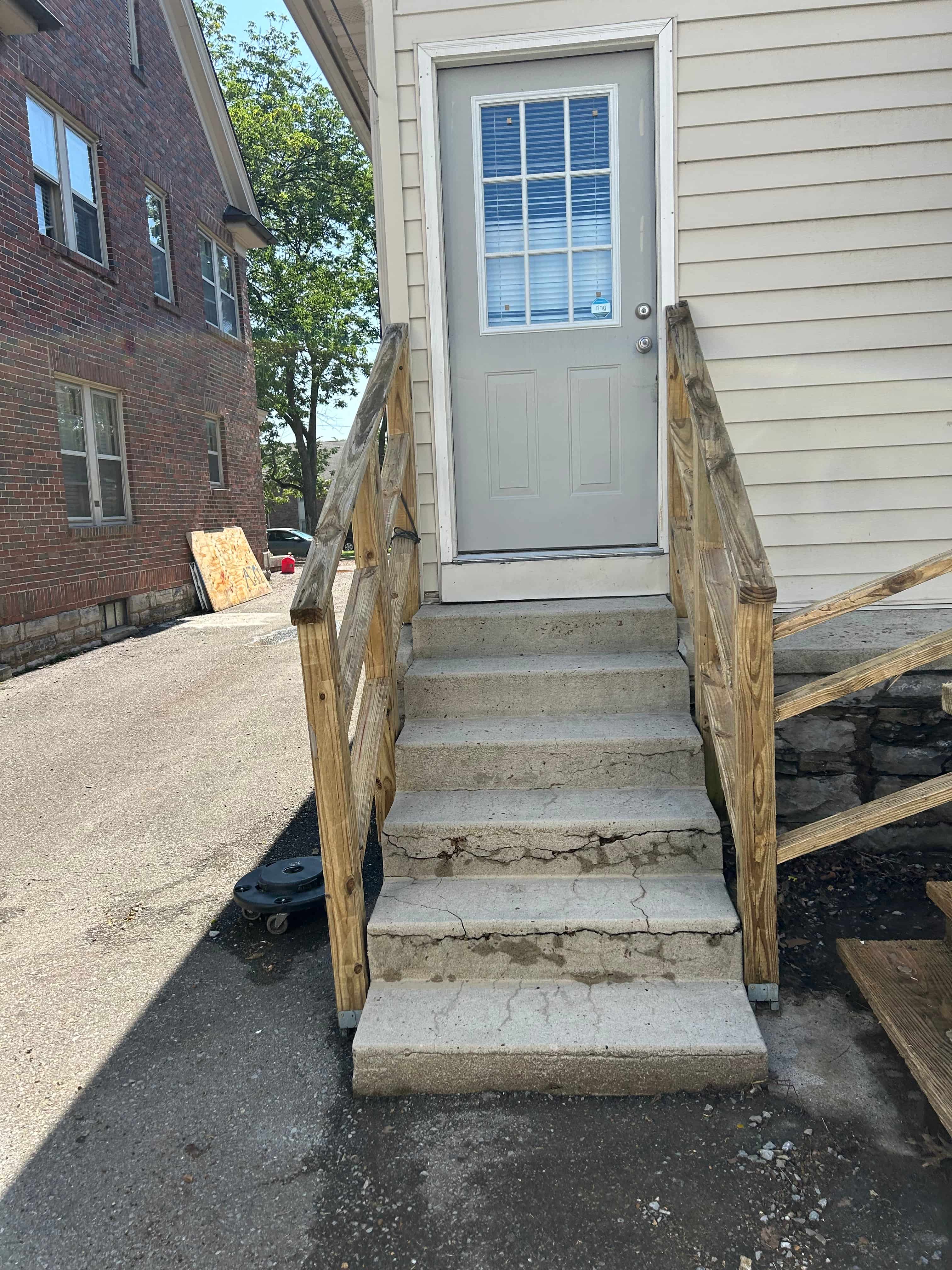 a set of stairs in front of a house with a white door