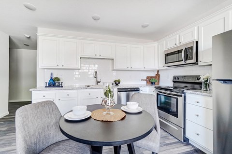 a kitchen with stainless steel appliances and a table and chairs