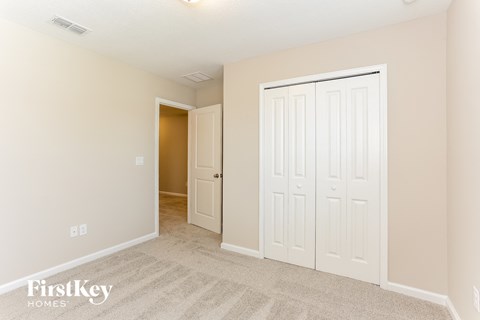 a bedroom with two closets and a door to a hallway