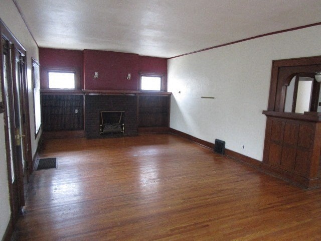 an empty living room with wood floors and a fireplace