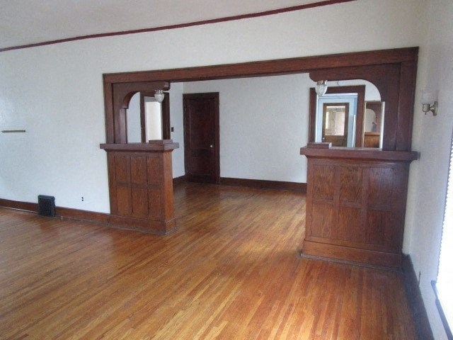 an empty living room with wooden floors and furniture