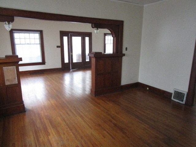 an empty living room with wooden floors and a door