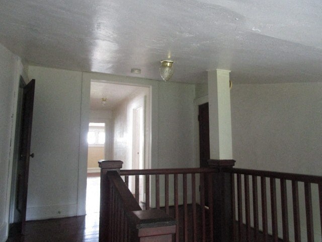 an empty room with a staircase and a door to a hallway