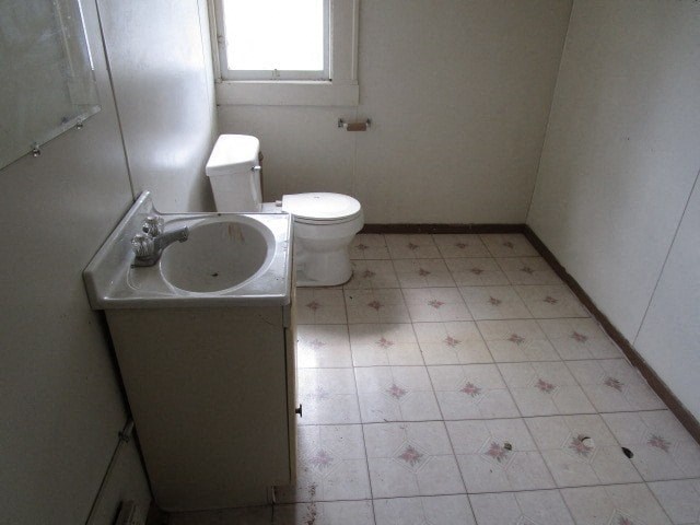 a bathroom with a toilet and a sink and a window